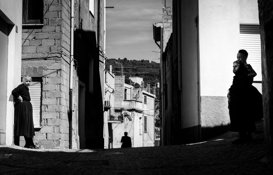 alcuni anziani in una via soleggiata di Orgosolo, Sardegna