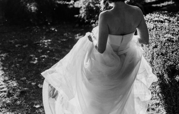 una sposa cammina al tramonto alzando il vestito