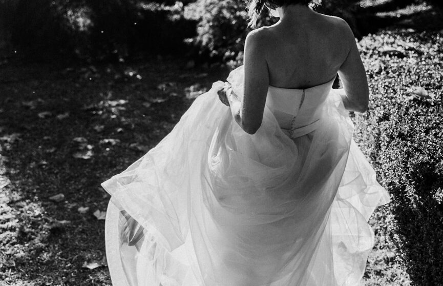 una sposa cammina al tramonto alzando il vestito