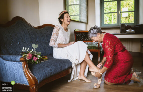 la sposa ride mentre la madre le inserisce le scarpe