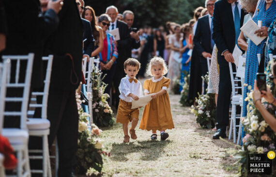 due bambini portano le fedi durante una cerimonia all'aperto