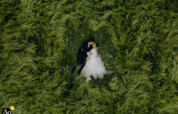 due sposi sdraiati su un campo di grano e fotografati dall'alto