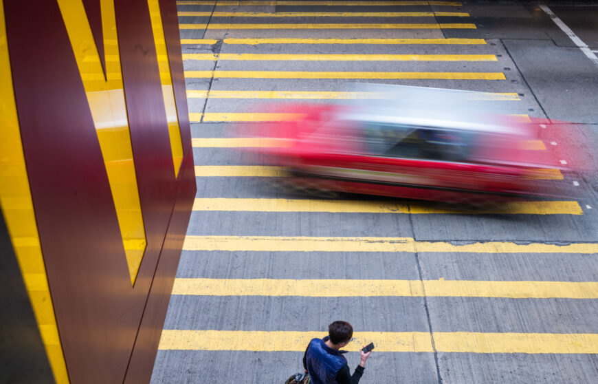 a car passing trough yellow lines in a street of Hong Kong