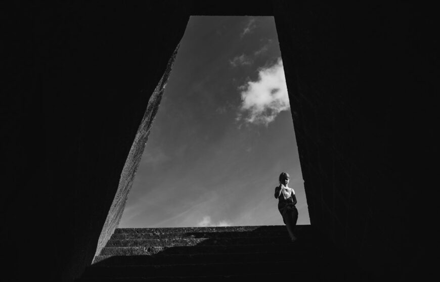 una bambina scende le scale del pozzo sacro di Santa Cristina in Sardegna