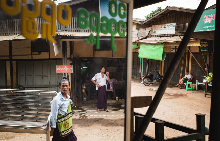 a man walking in a street market in myanmar