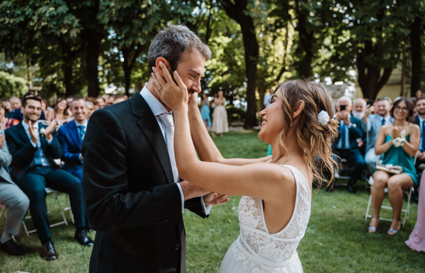 la sposa accarezza il viso dello sposo durante la celebrazione di un matrimonio all'aperto ad Alessandria