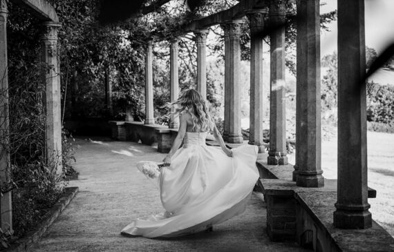 Una sposa ruota facendo volteggiare il vestito nella location giardini la pergola